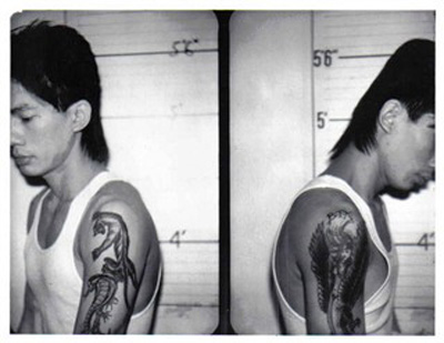 A BTK gang member displays his tattoos in a NYPD mugshot