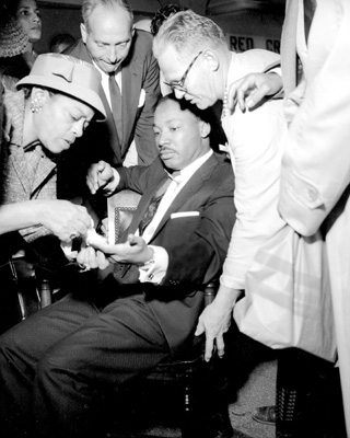 Martin Luther King, Jr., with letter opener protruding<br/> from his chest, after he was stabbed at a bookstore<br/> in Harlem.